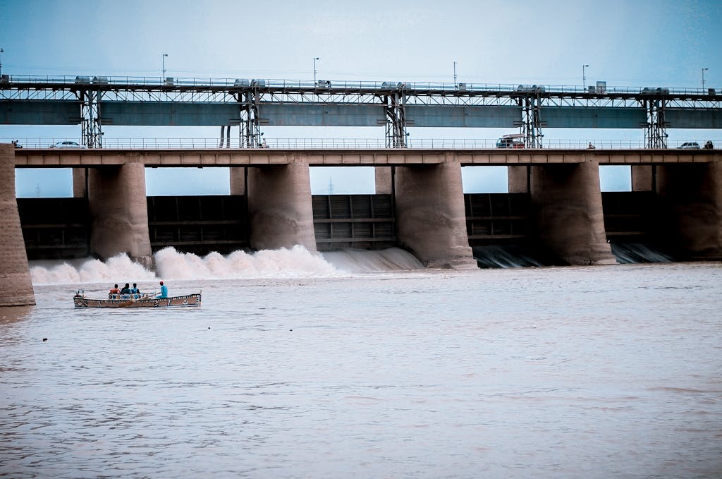 Hydroelectric dam in Jamshoro, Sindh with boat and people on Indus River.